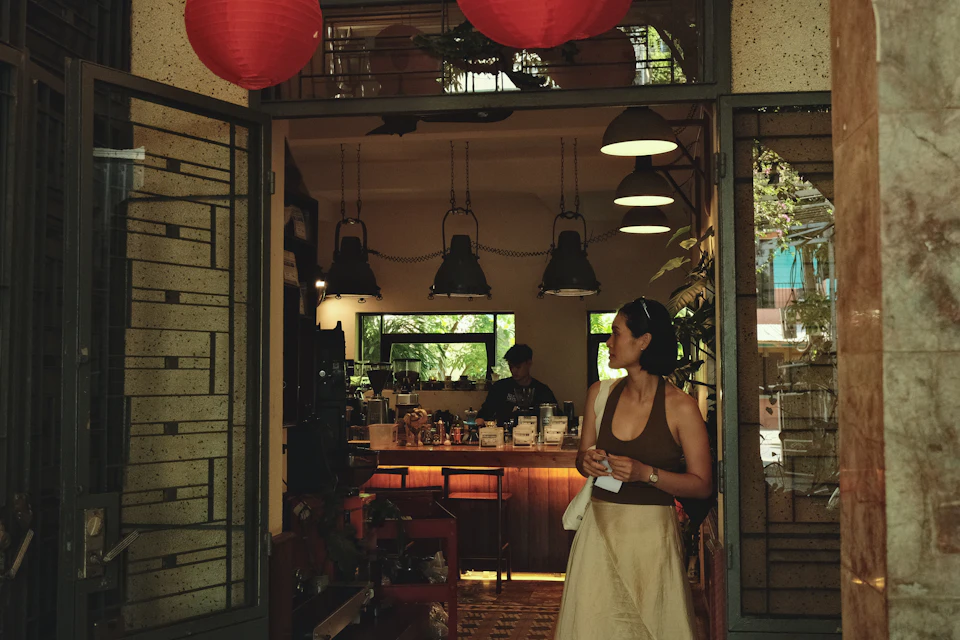 Mulher de pé à entrada de um café