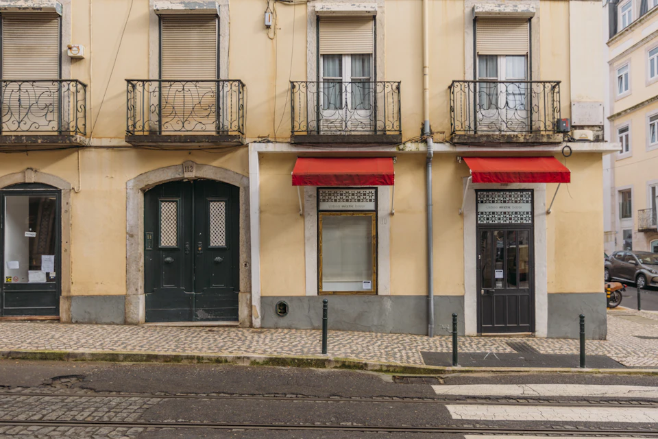 Porta de madeira preta num edifício da Calçada da Estrela, em Lisboa